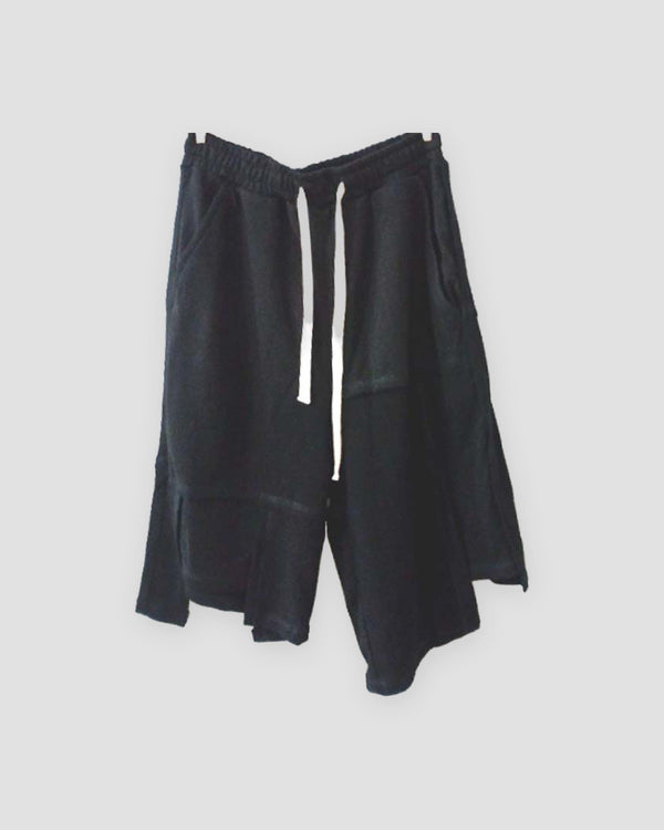 Black asymmetric panelled knee-length shorts with a cream drawcord, front view