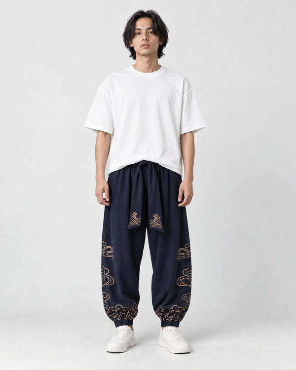 Model wearing the navy cloud-embroidered lantern pants with a white tee and white sneakers, front view