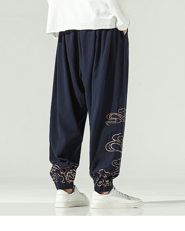 Navy lantern pants with gold cloud embroidery on the lower legs and a knotted sash, worn with a white shirt