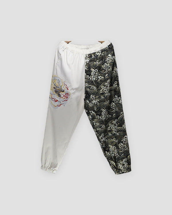Cream and wave-print jogger pants with an embroidered dragon on the cream leg, front view