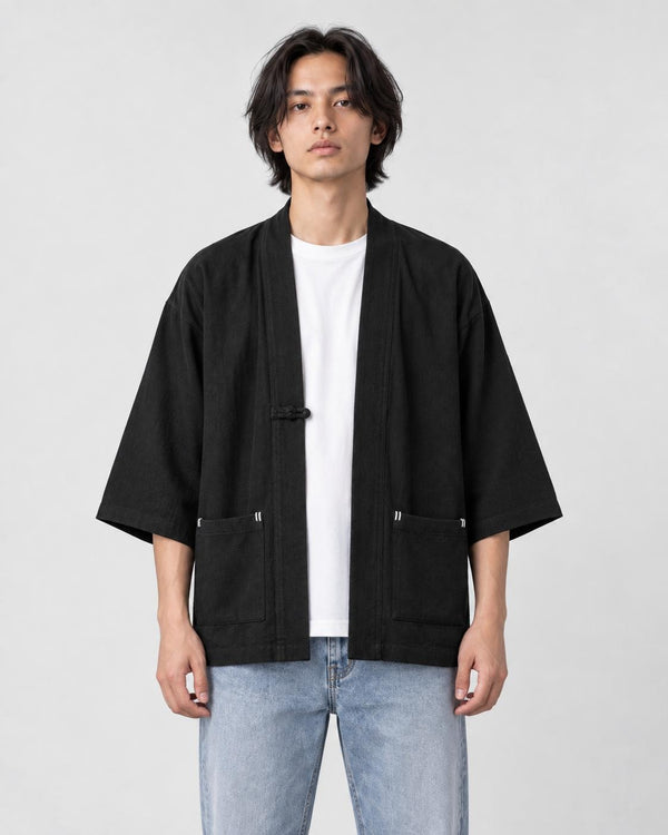 Model wearing the black linen haori cardigan open over a white tee and light-wash jeans, front view