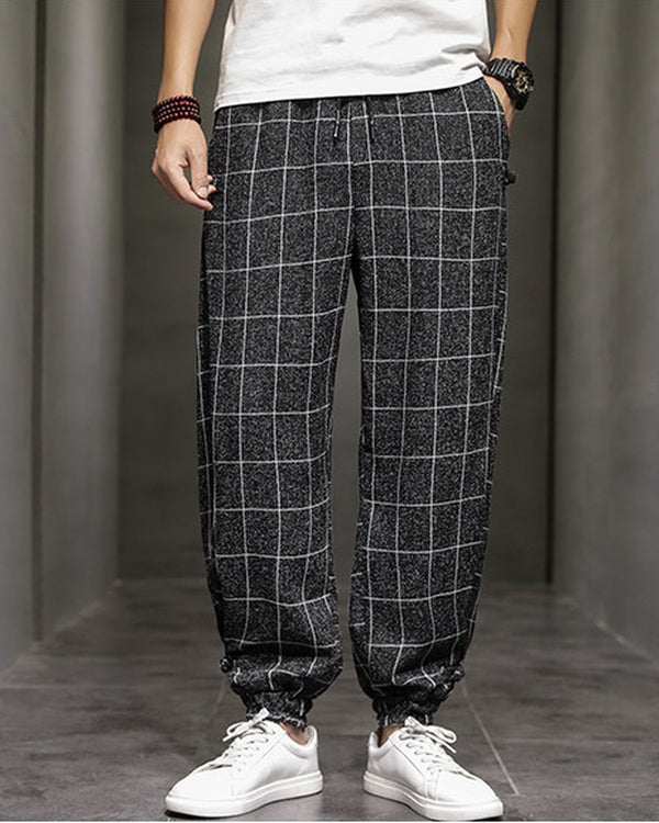 Black plaid harem pants with frog-button knots at the hips, worn with a white tee and white sneakers