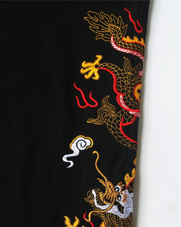 Close-up of the gold, red and white dragon embroidery on the leg