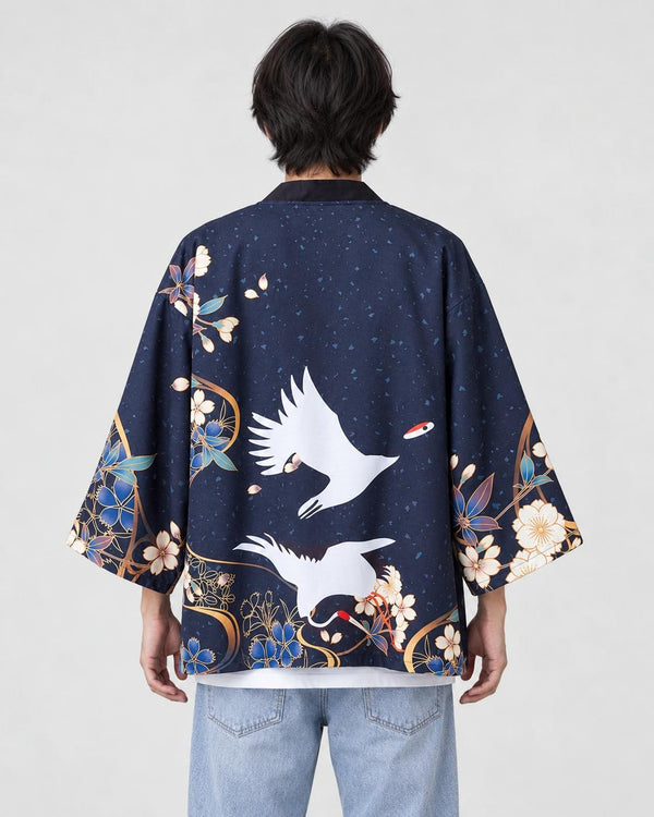 Man seen from behind in the dark navy haori with two white cranes in flight and blue flowers at the hem, over a white tee