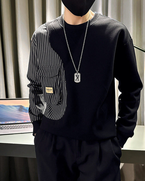 Black crewneck sweatshirt with a pinstripe panel down the right sleeve and two flap pockets, worn with black trousers