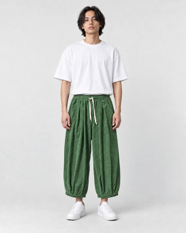 Model wearing the green corduroy wide-leg pants with a white tee, front view