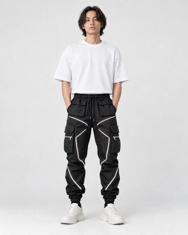 Model wearing black cargo joggers with silver reflective tape lines, a white tee and chunky sneakers, front view
