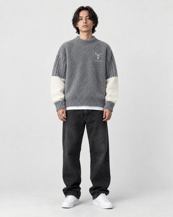 Model wearing the gray stag motif sweater with jeans, front view