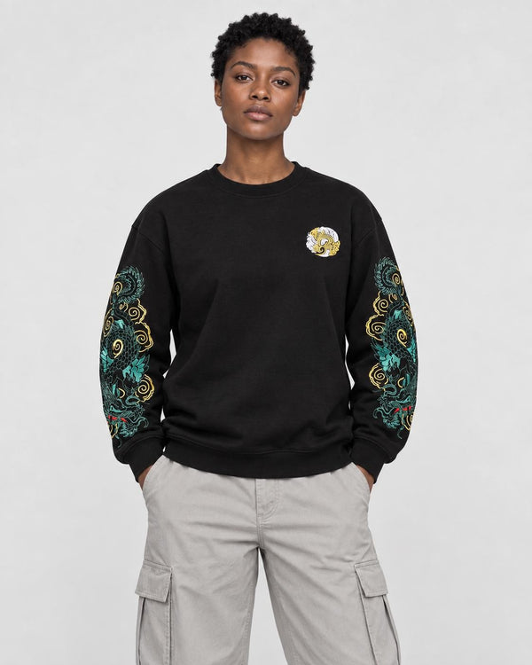 Model wearing the black twin dragon sleeve sweatshirt with stone trousers, front view