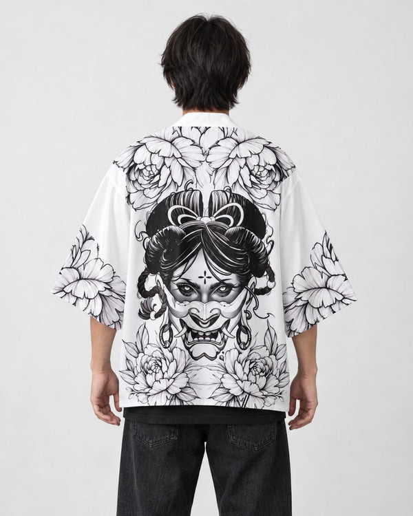 Man seen from behind in the white haori printed with a black line-art demon mask and peonies, over a black tee