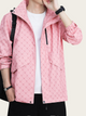 Person wearing a pink jacket with a pattern, white shirt, and black pants on a light gray background