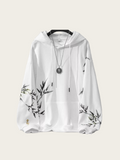 White hoodie with black floral patterns on sleeves against a white background