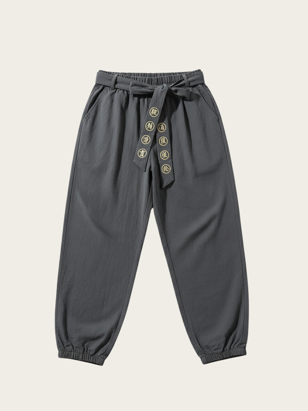 Gray pants with button details on a beige background