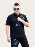 Person wearing a black polo shirt and pants with butterfly designs on a plain background
