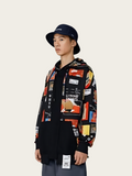 Person wearing a black jacket with colorful graphic designs and a black hat on a white background