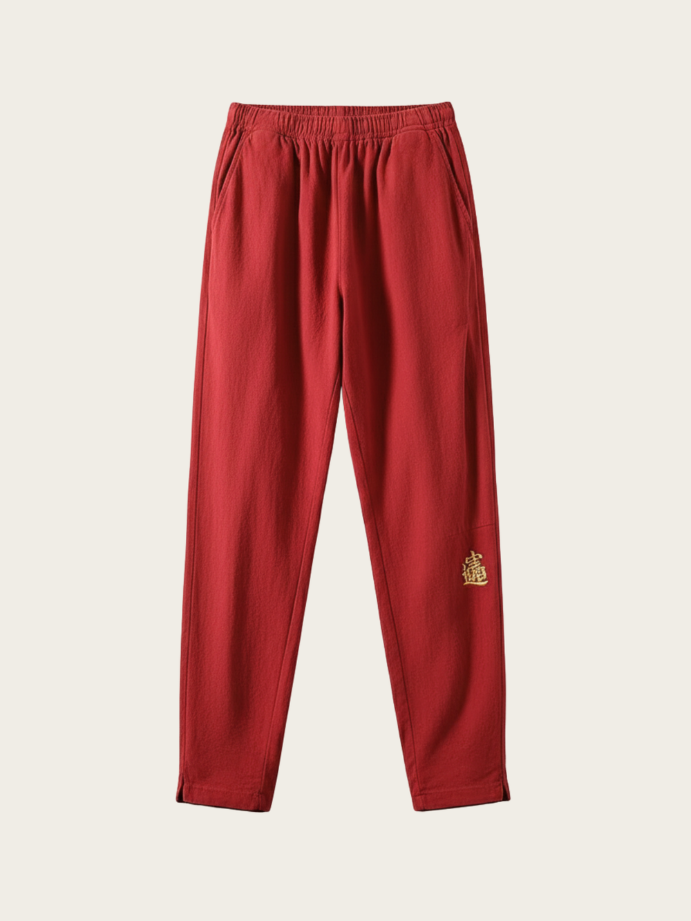 Red pants with a gold emblem on a beige background