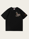 Black t-shirt with floral embroidery on a beige background