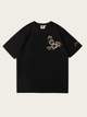 Black t-shirt with floral embroidery on a beige background