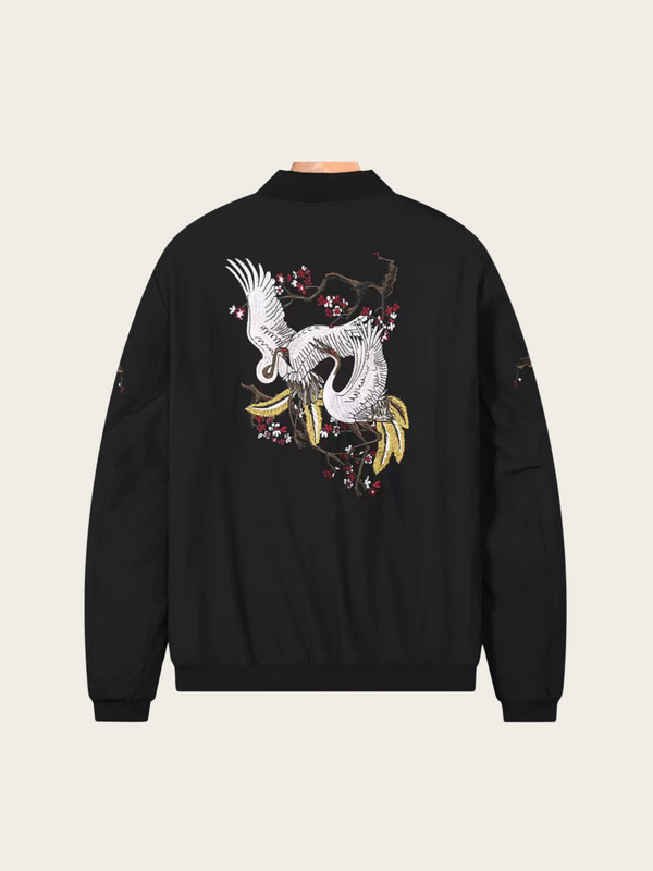 Black sweatshirt with a white graphic design on the back against a beige background