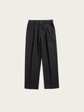 Black pleated pants on a light beige background