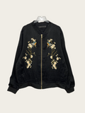 Black bomber jacket with floral embroidery on a white background