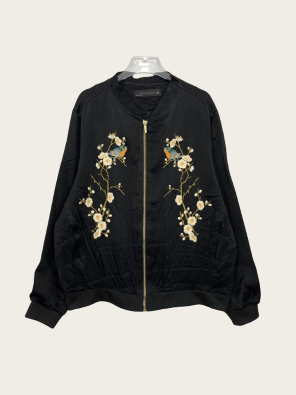 Black bomber jacket with floral embroidery on a white background