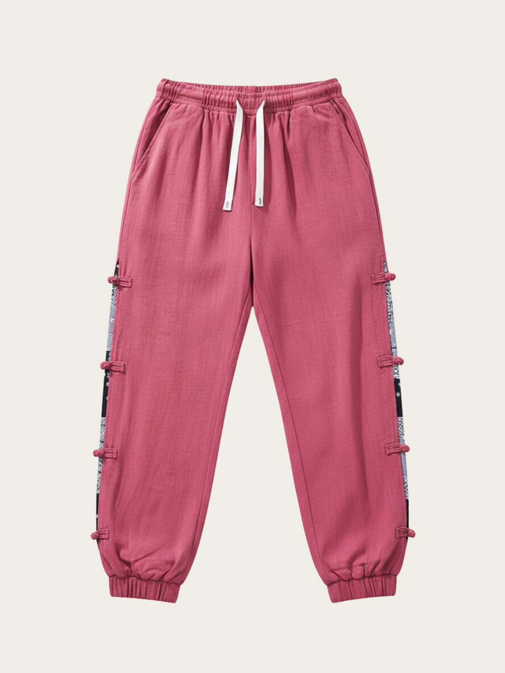 Pink jogger pants with side stripes on a beige background