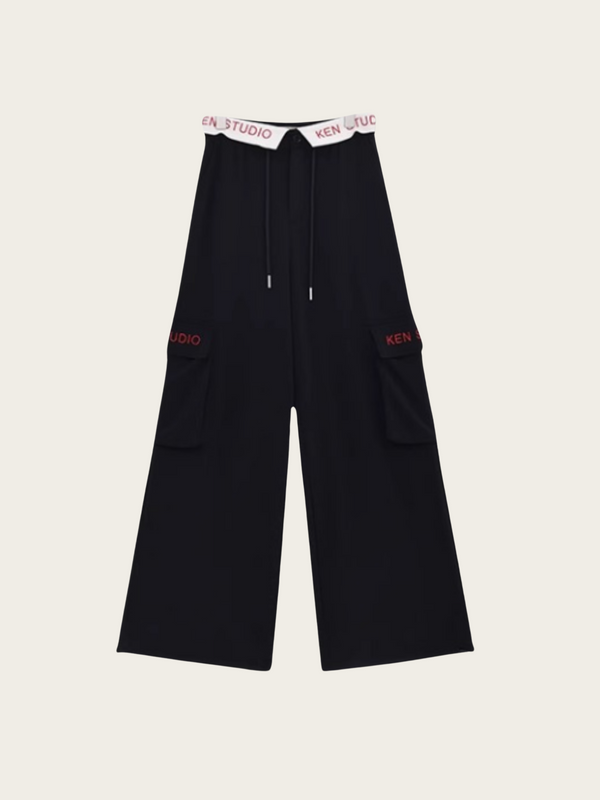 Black wide-leg pants with red branding on a light beige background