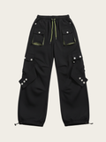 Black cargo pants with multiple pockets and buttons on a beige background