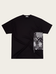 Black t-shirt with a patterned patch on a beige background