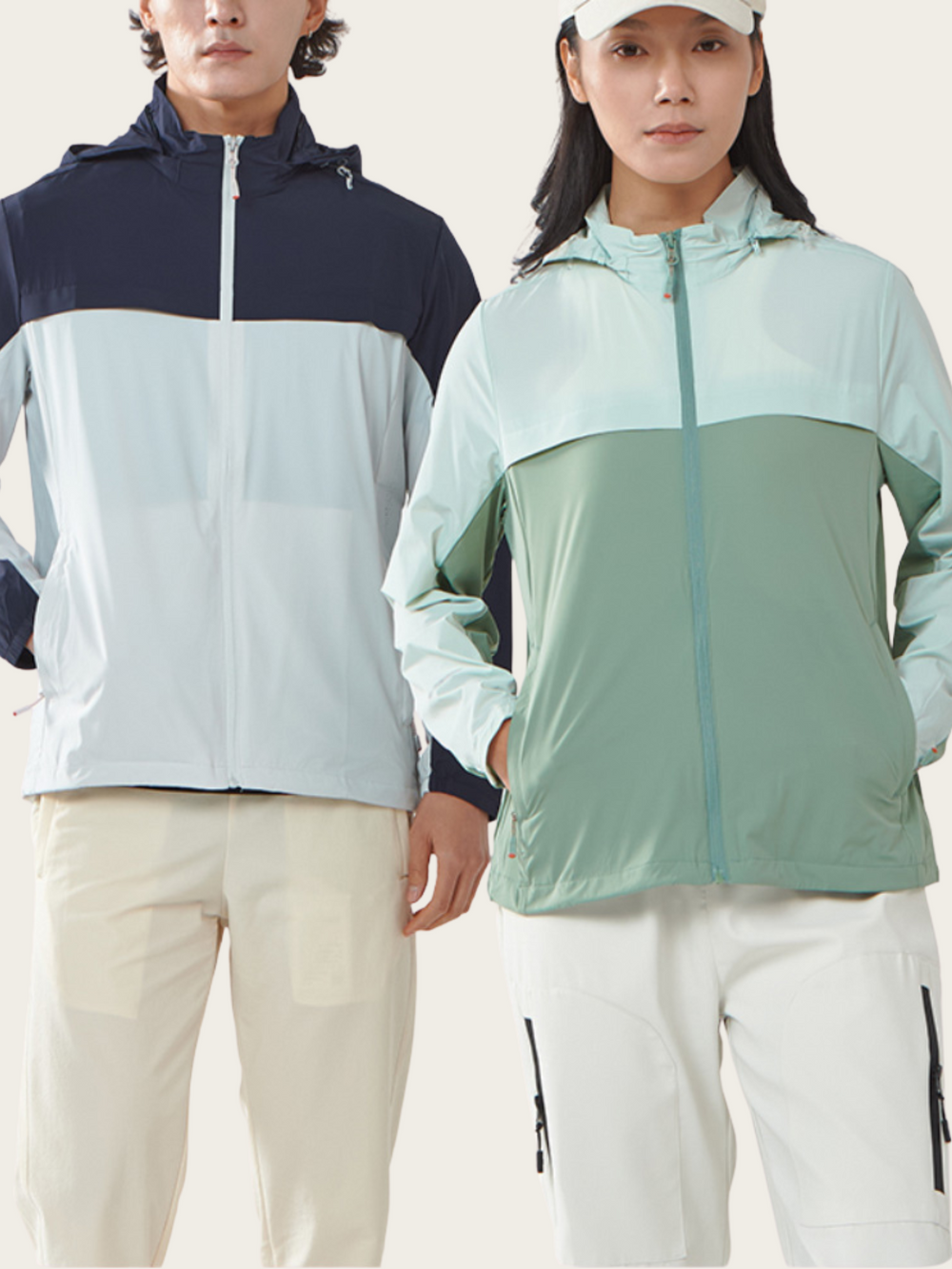 Two people wearing color-blocked jackets on a plain background