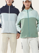 Two people wearing color-blocked jackets on a plain background