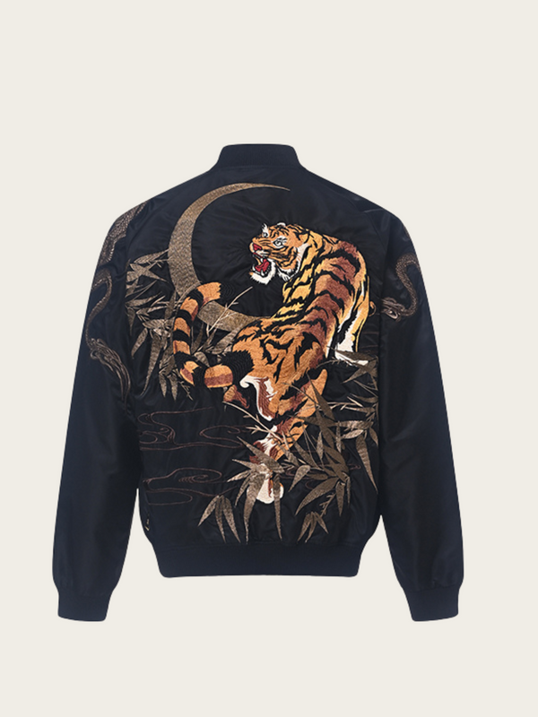 Navy blue jacket with a tiger and moon design on the back against a beige background
