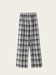 Black and white plaid pants on a beige background