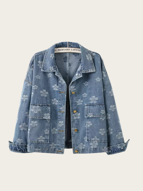 Blue denim jacket with floral patterns on a beige background