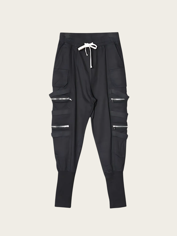 Black jogger pants with zippers on a beige background