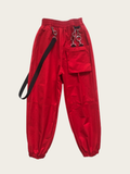 Red pants with black straps on a beige background