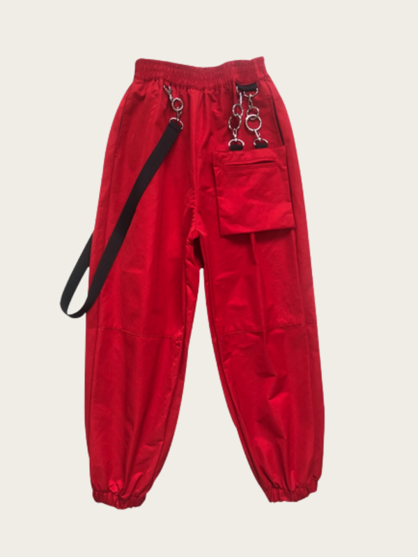 Red pants with black straps on a beige background