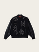 Black jacket with white designs on a beige background