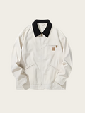 White jacket with black collar on a light beige background