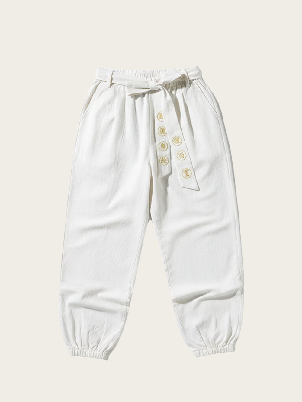 White pants with button details on a beige background