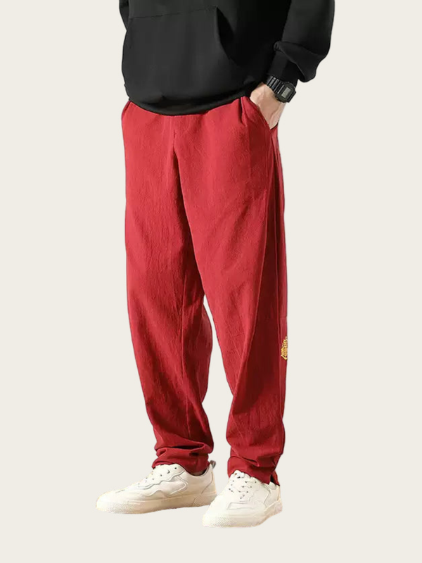 Person wearing red pants and a black top on a light gray background