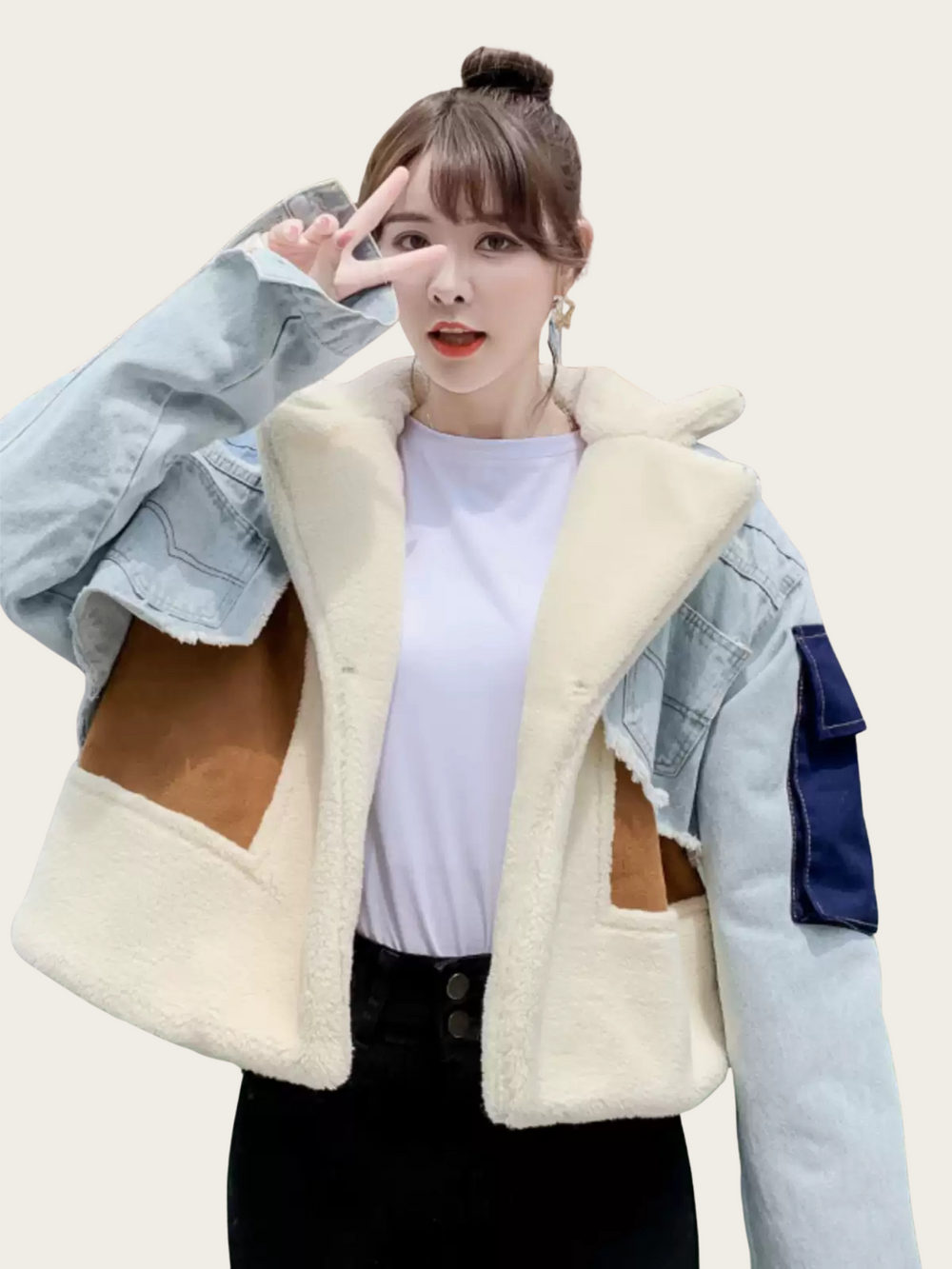 Person wearing a white fleece-lined jacket with denim sleeves on a plain background