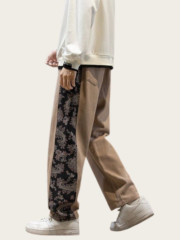 Person wearing beige pants with a black and white patterned side panel on a white background