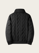 Black quilted jacket on a light gray background