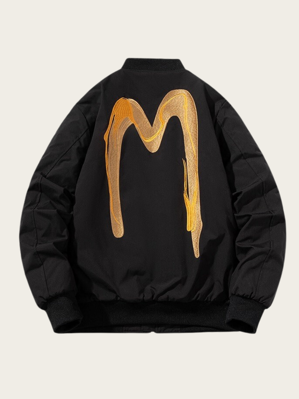 Black jacket with gold abstract design on the back against a beige background