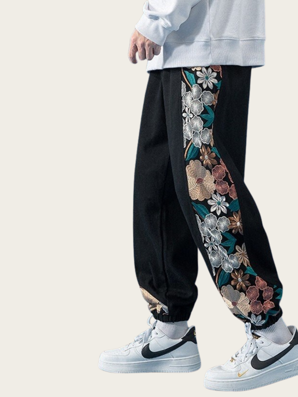 Black pants with floral patterns on a plain background