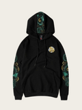 Black hoodie with green and gold designs on sleeves and chest on a beige background