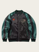 Black and green jacket with patches on a beige background