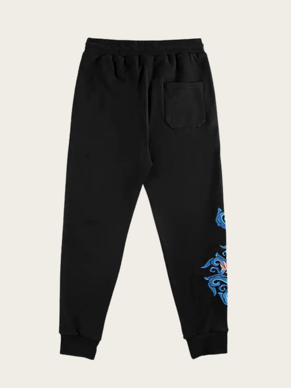Black sweatpants with blue designs on a beige background